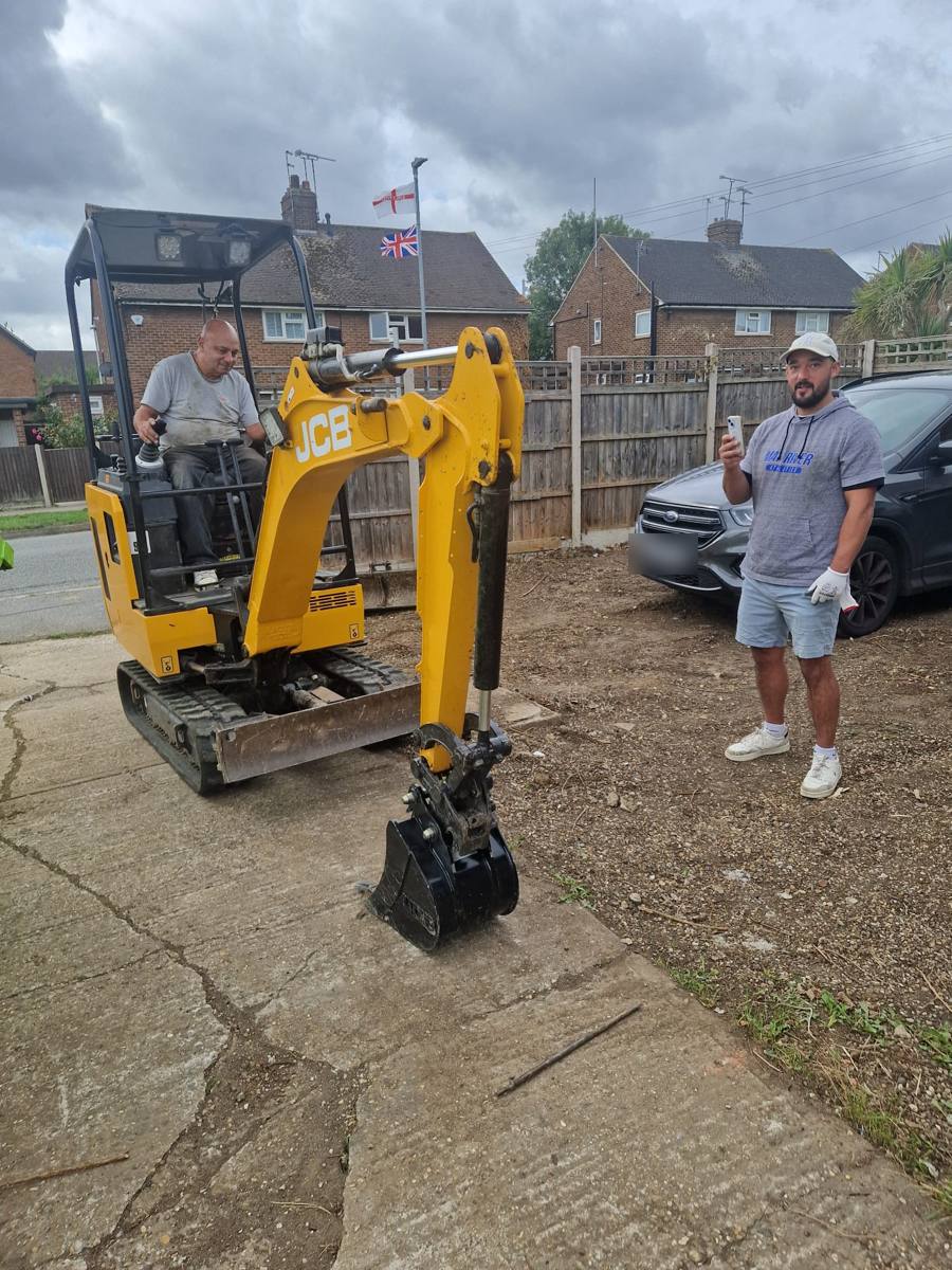 Yellow JCB mini digger on a driveway ready to dig out for groundworks